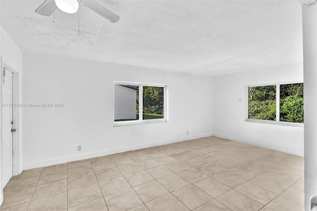 tiled spare room with a textured ceiling and ceiling fan