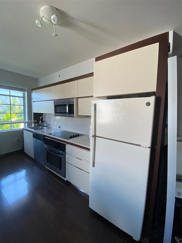 kitchen featuring white cabinets, decorative backsplash, sink, and appliances with stainless steel finishes