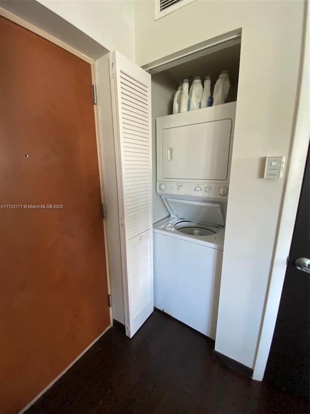 clothes washing area featuring stacked washing maching and dryer