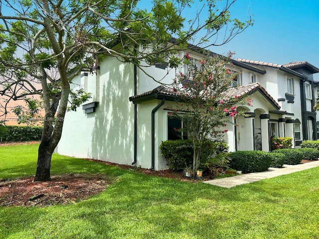 view of property exterior with a lawn