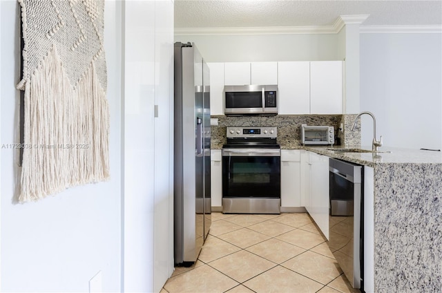 kitchen with stainless steel appliances, white cabinetry, sink, and light tile patterned floors