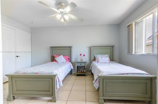 tiled bedroom featuring ceiling fan and a textured ceiling