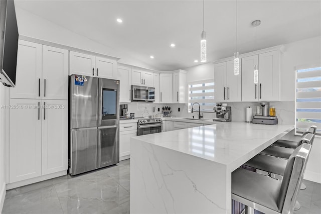 kitchen featuring white cabinetry, sink, stainless steel appliances, kitchen peninsula, and pendant lighting