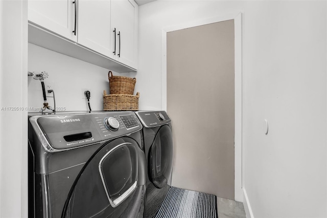 laundry room featuring washing machine and dryer and cabinets