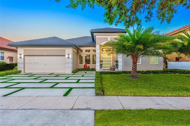 view of front facade with a garage and a lawn