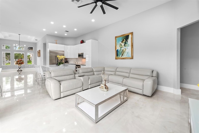 living room featuring ceiling fan with notable chandelier