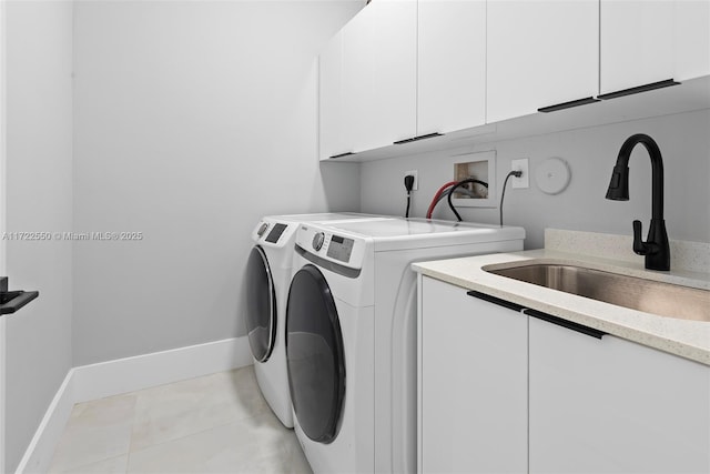 clothes washing area featuring cabinets, light tile patterned flooring, washing machine and clothes dryer, and sink