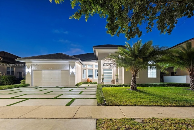 view of front of home featuring a garage and a front lawn