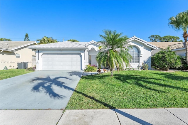 view of front of property featuring a garage, a front yard, and central AC