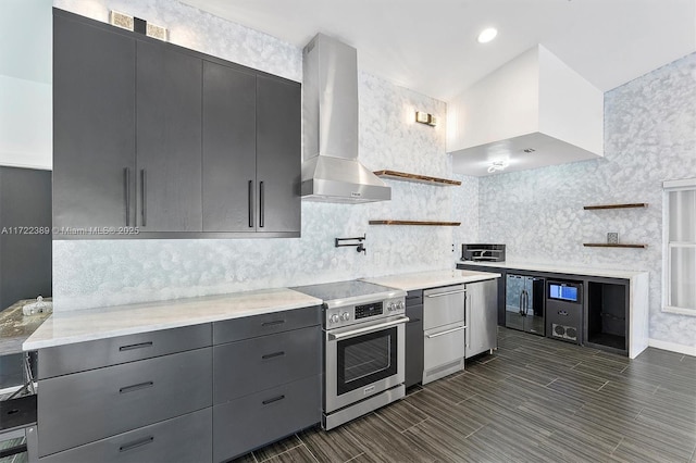 kitchen featuring backsplash, gray cabinetry, wall chimney range hood, electric range, and fridge