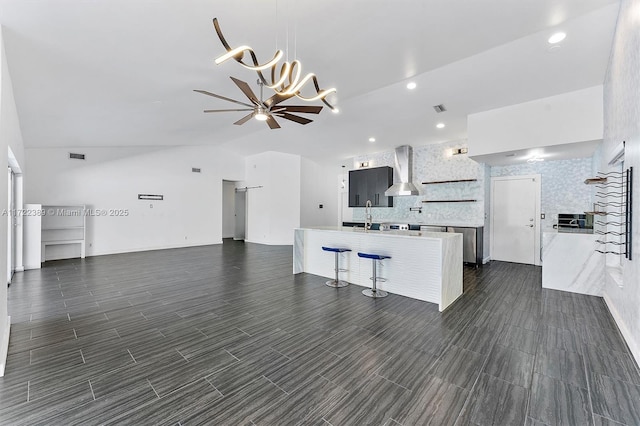 unfurnished living room with ceiling fan and lofted ceiling