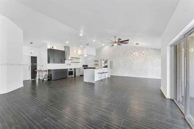 living room featuring ceiling fan and vaulted ceiling