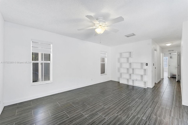 unfurnished room with ceiling fan and a textured ceiling