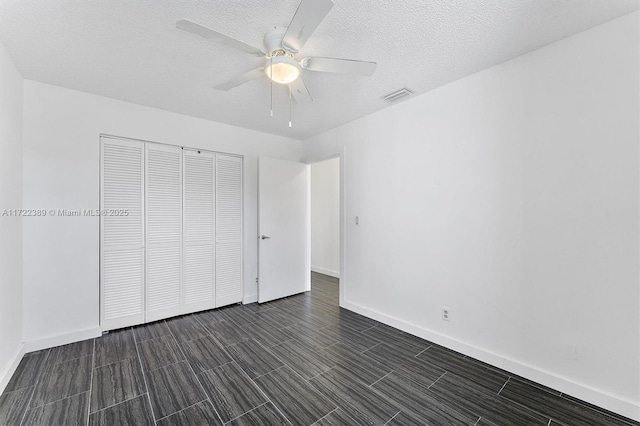 unfurnished bedroom with ceiling fan and a closet