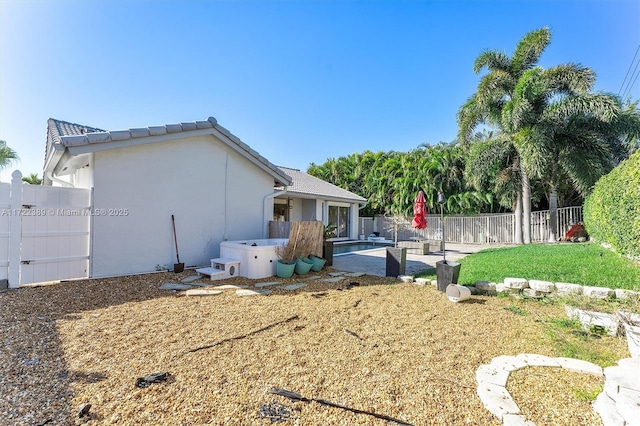 back of house with a pool with hot tub