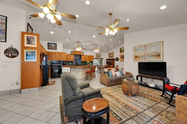 living room featuring ceiling fan, light tile patterned floors, and vaulted ceiling