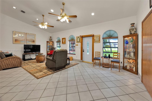 tiled living room with ceiling fan and vaulted ceiling