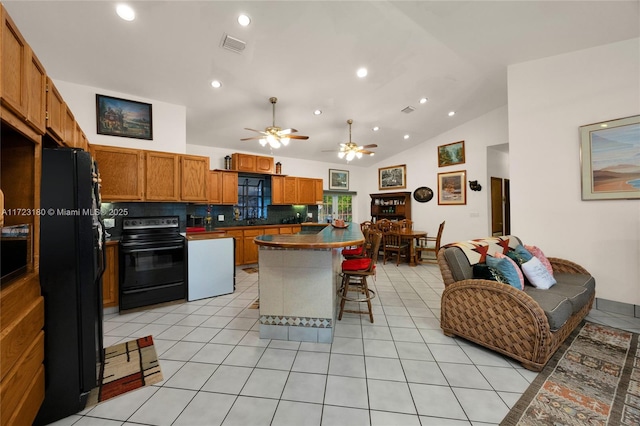 kitchen featuring ceiling fan, lofted ceiling, a breakfast bar area, decorative backsplash, and black appliances