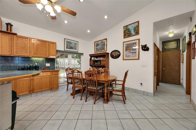 tiled dining space with ceiling fan and lofted ceiling