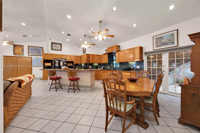 dining space with light tile patterned floors and lofted ceiling