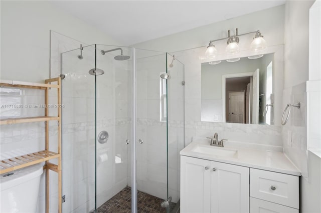 bathroom featuring vanity, toilet, and a shower with door