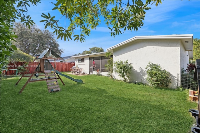 view of yard with a playground and a sunroom