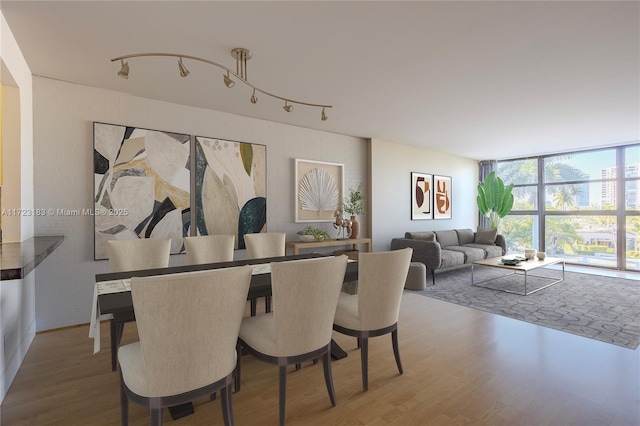 dining room with hardwood / wood-style floors and a wall of windows