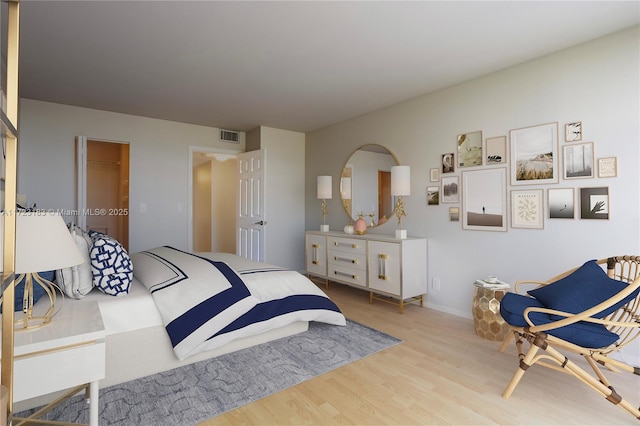 bedroom featuring a closet, light hardwood / wood-style flooring, and a spacious closet