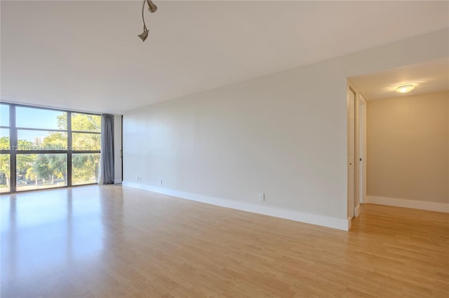 spare room featuring light hardwood / wood-style flooring and floor to ceiling windows