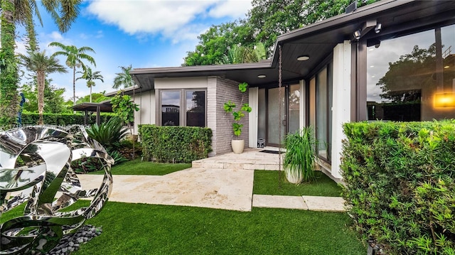 doorway to property featuring a yard