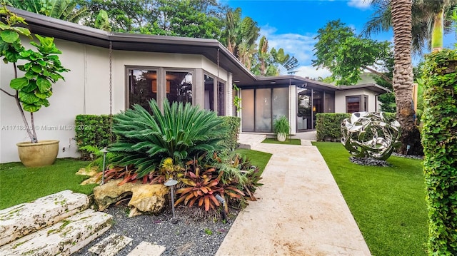 view of front of house featuring a sunroom and a front lawn