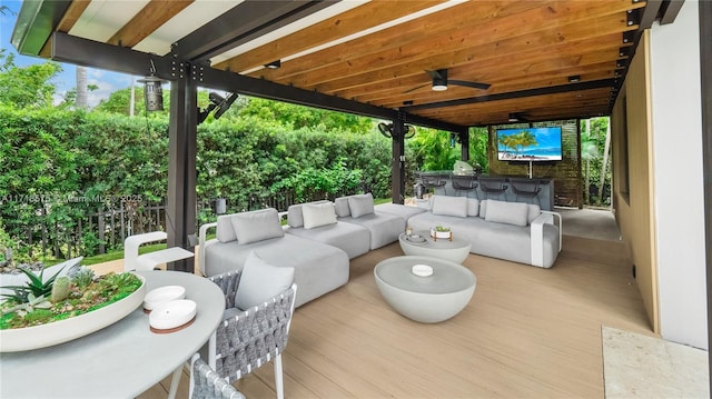 view of patio with an outdoor living space, ceiling fan, exterior bar, and a wooden deck