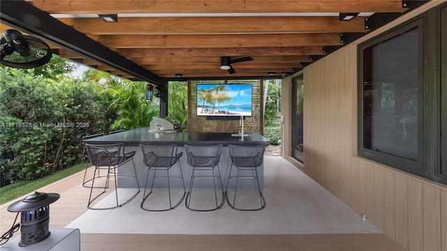 view of patio / terrace with ceiling fan, an outdoor bar, and a deck