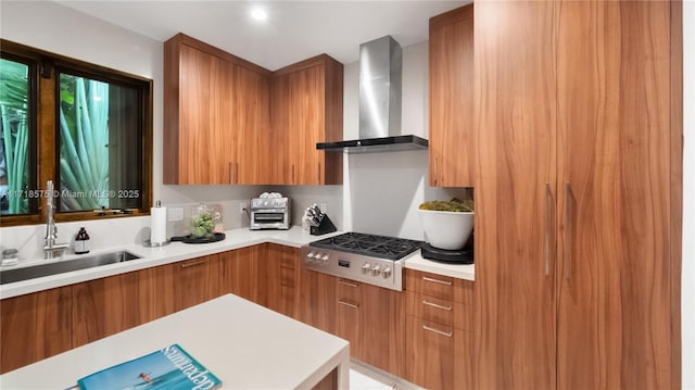 kitchen with wall chimney exhaust hood, sink, and stainless steel gas stovetop