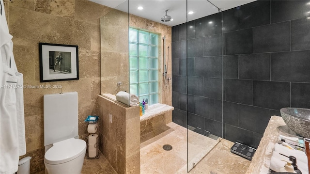 bathroom with toilet, a shower, and tile walls