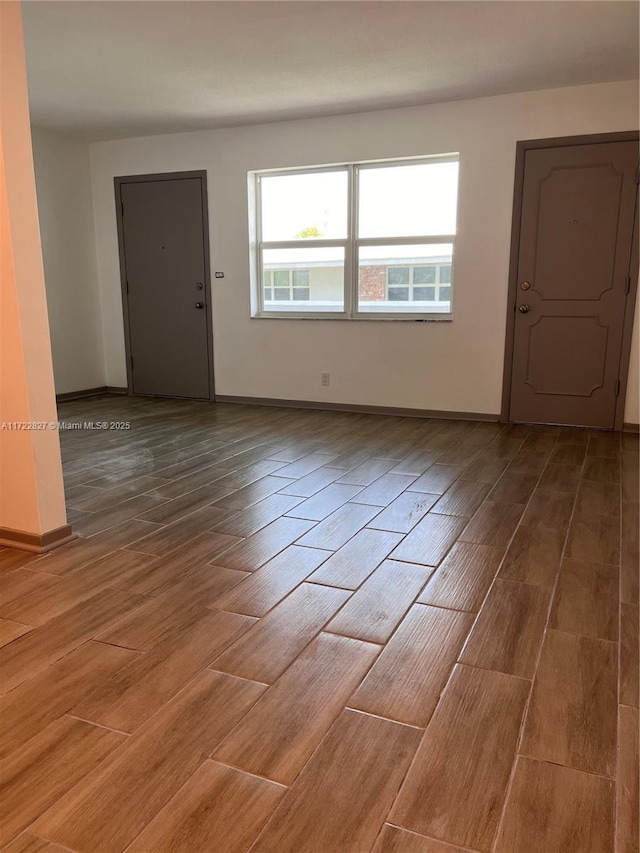 unfurnished room with hardwood / wood-style flooring