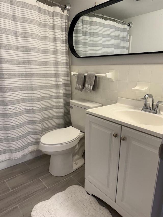 bathroom with toilet, backsplash, tile walls, a shower with curtain, and vanity