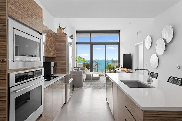 kitchen with an island with sink, oven, and sink