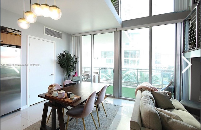 dining room with plenty of natural light, light tile patterned floors, and a wall of windows