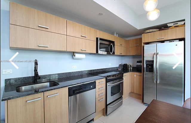 kitchen with sink, light brown cabinets, stainless steel appliances, dark stone counters, and light tile patterned flooring