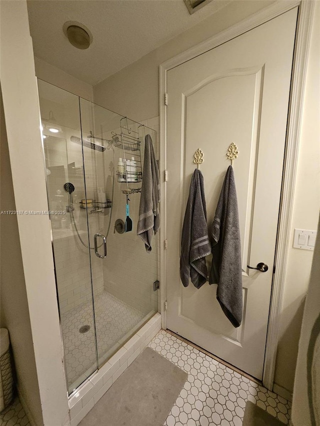 bathroom featuring tile patterned flooring and a shower with shower door