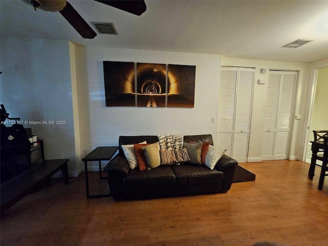 living room featuring ceiling fan and hardwood / wood-style floors