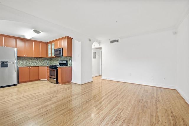 kitchen featuring light wood-type flooring, appliances with stainless steel finishes, and tasteful backsplash