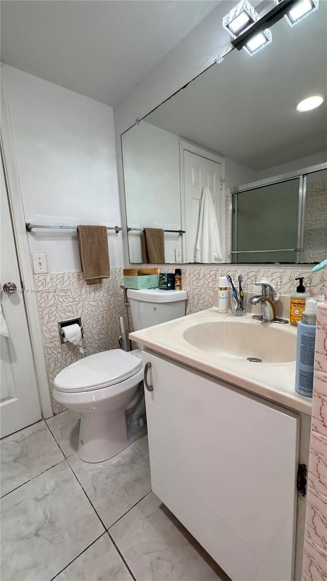 bathroom featuring vanity, an enclosed shower, and toilet