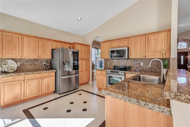 kitchen with appliances with stainless steel finishes, tasteful backsplash, sink, light brown cabinets, and light tile patterned floors