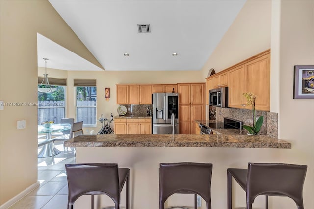 kitchen featuring kitchen peninsula, backsplash, stainless steel appliances, light tile patterned floors, and lofted ceiling