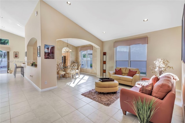 tiled living room featuring lofted ceiling and an inviting chandelier