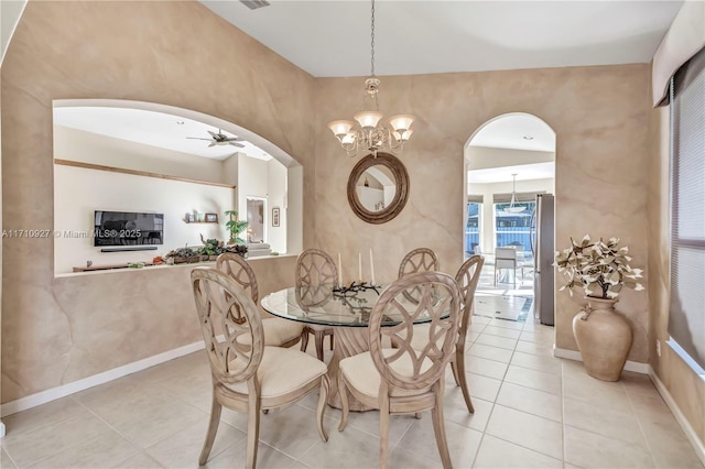 tiled dining area with ceiling fan with notable chandelier