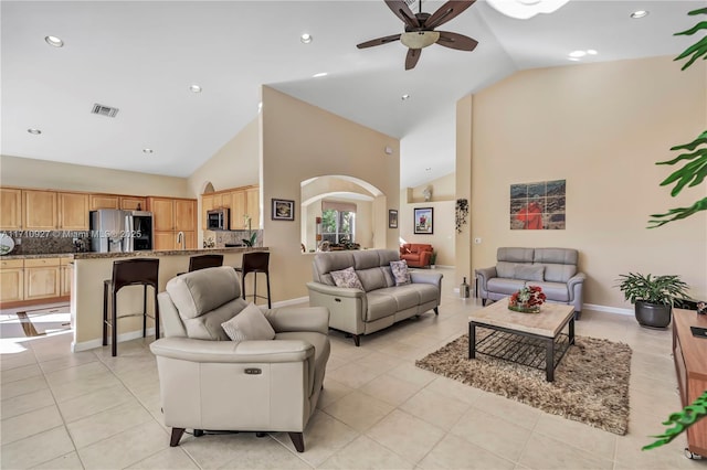 tiled living room featuring high vaulted ceiling and ceiling fan