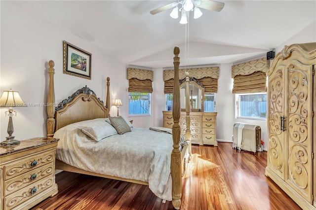 bedroom with multiple windows, ceiling fan, hardwood / wood-style floors, and lofted ceiling